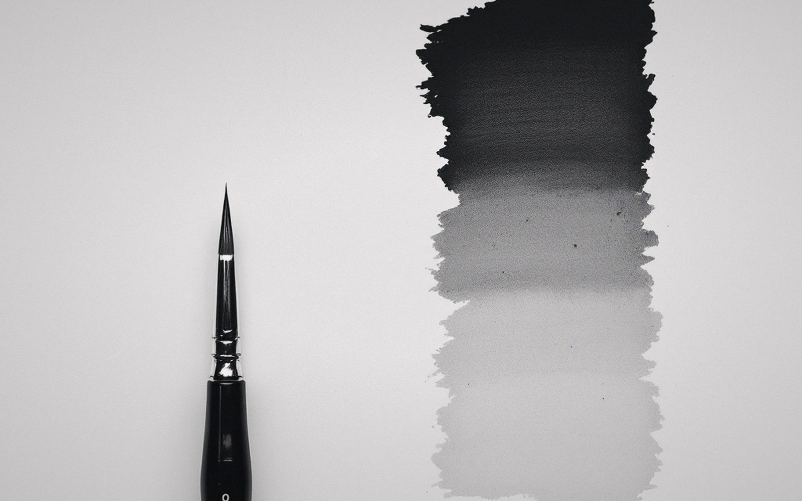 Fine liner brush beside an ink wash gradient fading from black to pale gray